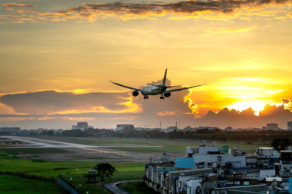 Airplane taking off from Ninoy Aquino International Airport over Manila city skyline, Philippines