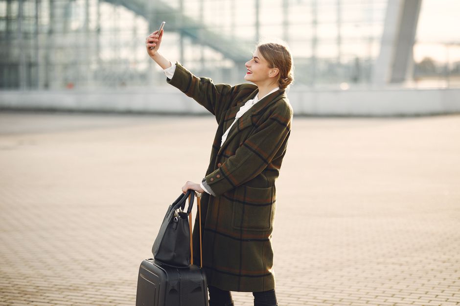 Tourist holding a smartphone at Ninoy Aquino International Airport in the Philippines, ready to activate a local SIM card