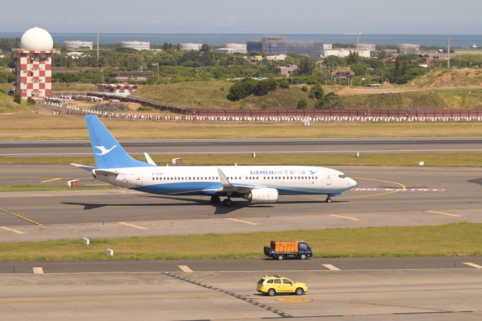 Airplane landing at Taiwan Taoyuan International Airport (TPE) with Taipei skyline in the background
