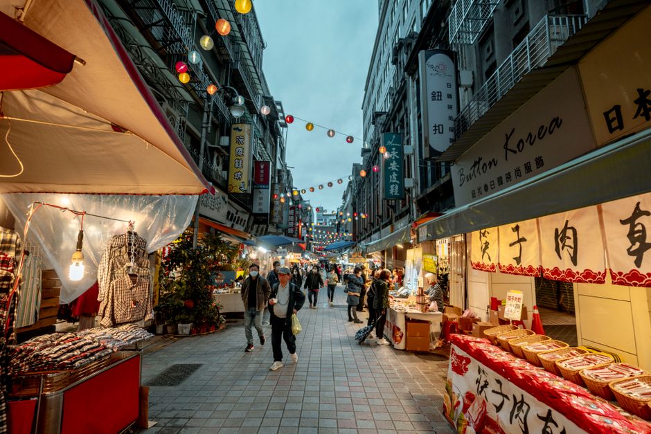 Vibrant street food stall at a bustling night market in Taiwan, showcasing various local delicacies.